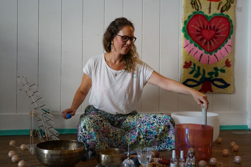 Flora Wirth assise parmi ses bols chantants, dans son espace de soins à Lausanne